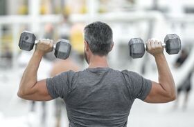 Mężczyzna trenujący siłowo. Leucyna, l-leucyna, suplementacja leucyną.