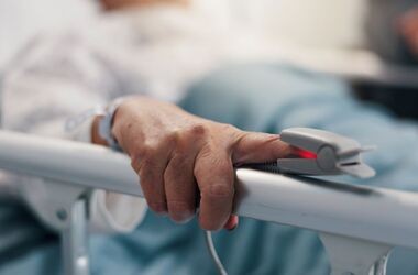 Dłoń pacjent z nałożonym pulsoksymetrem, powikłania po grypie, powikłania grypy, powikłania pogrypowe.