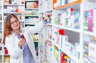 Farmaceutka wystawia leki na półce z nowej listy refundacyjnej 1 kwietnia 2024 roku