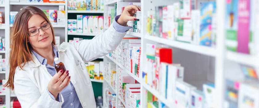 Farmaceutka wystawia leki na półce z nowej listy refundacyjnej 1 kwietnia 2024 roku
