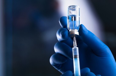 Zdjęcie igly wbitej w fiolkę z preparatem szczepionkowym