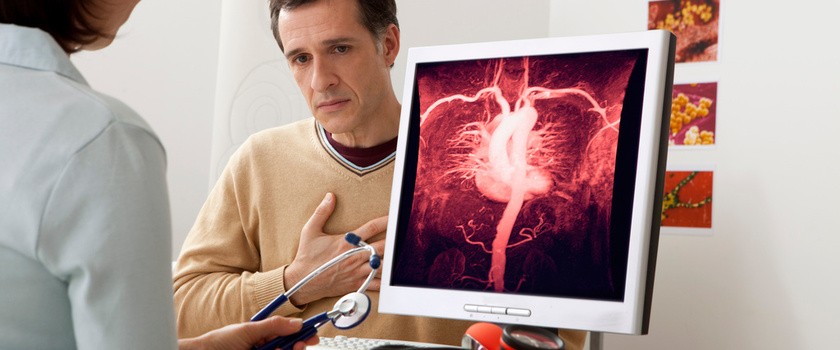 pacjent u lekarza kardiologa, trzyma dłoń na klatce piersiowej