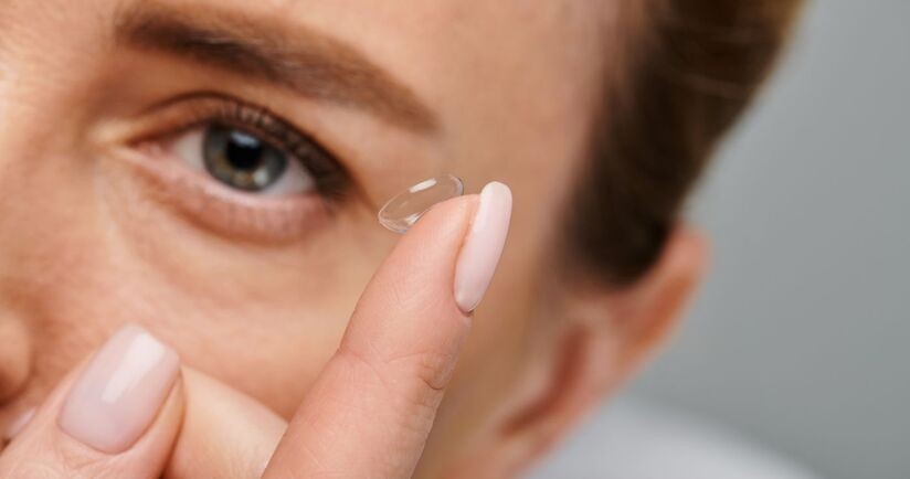 kobieta zakładająca soczewki kontaktowe, rodzaje soczewek, typy soczewek, które soczewki kiedy wybrać, jak dobiera się soczewki, soczewki a wady wzroku