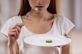 Dziewczyna z anoreksją je symboliczną porcję jedznia