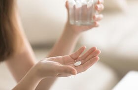 Tabletka na kobiecej dłoni - zdjęcie ilustracyjne