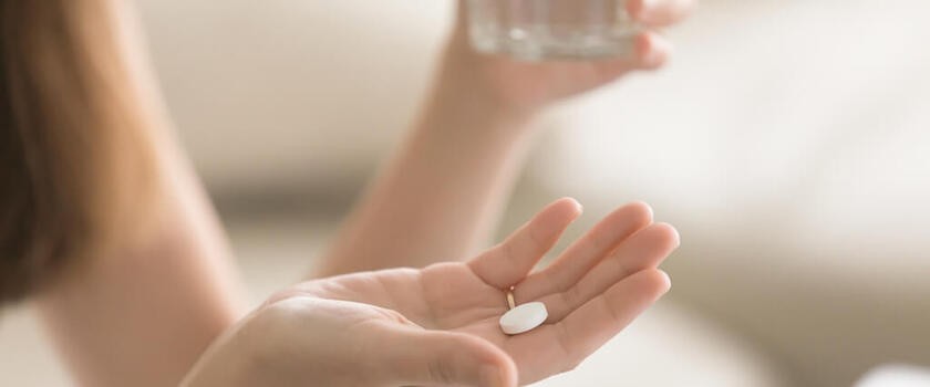 Tabletka na kobiecej dłoni - zdjęcie ilustracyjne