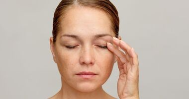 Kobieta dotyka powieki, zakażenie nużeńcem, nużeniec, objawy nużeńca.