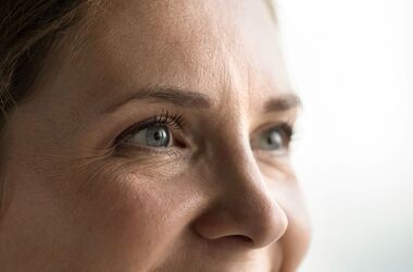 Zbliżenie na kobiecą twarz ze zmarszczkami wokół oczu. Kurze łapki, zmarszczki kurze łapki. 