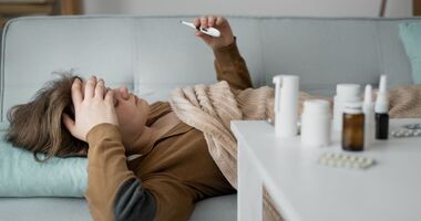 wzrost zakażeń grypą, zachorowania na grypę, szczyt zachorowań na grypę w Polsce, kobieta chora na grypę mierzy temperaturę