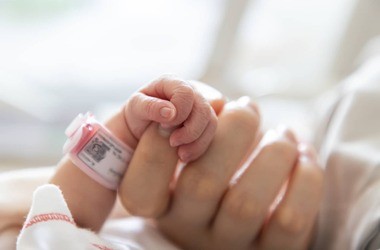 noworodek trzyma palec mamy
