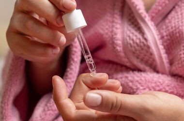 kobieta stosująca preparat na onycholizę paznokci, onycholiza co to, leczenie onycholizy panzokci