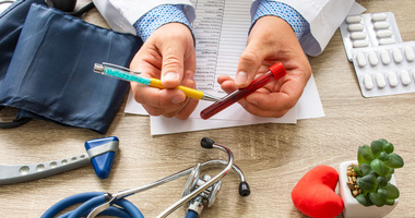 lekarz trzymający probówkę z krwią i tłumaczący co to jest anemia