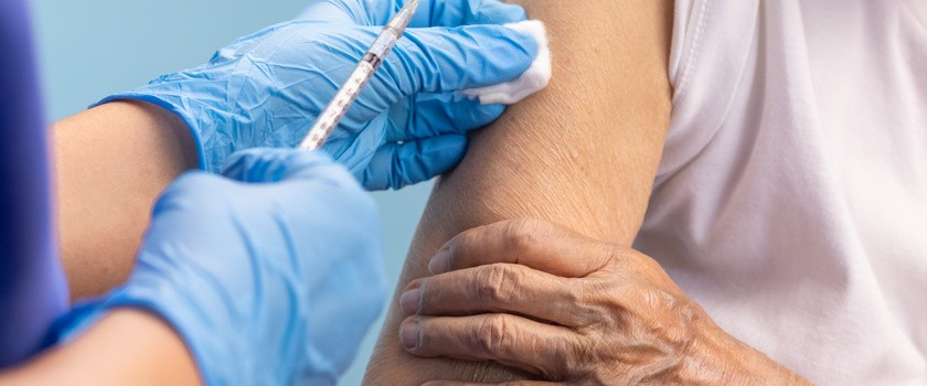Medyk szczepi starszą osobę. Rekordowa liczba szczepień przeciwko grypie.