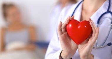 Lekarka trzymająca w dłoniach plastikowe serca. Klopidogrel czy aspiryna?