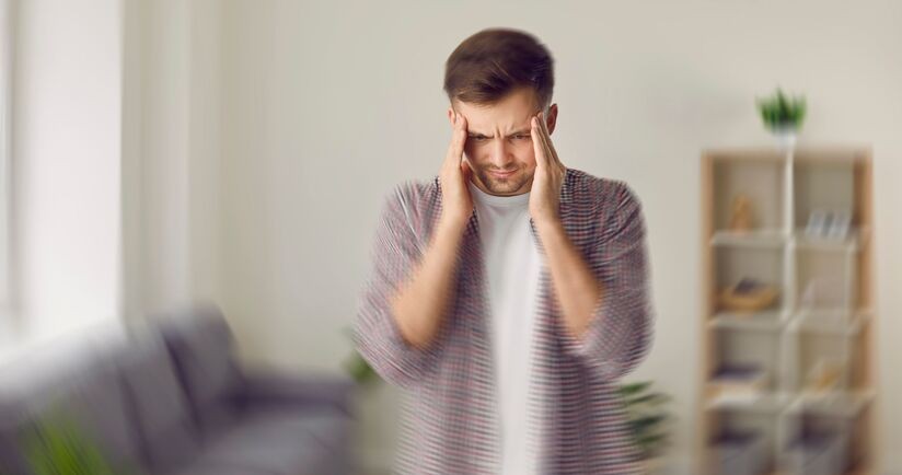 zapalenie opon mózgowo-rdzeniowych, mężczyzna trzymający się za głowę, objawy zapalenia opon mózgowo-rdzeniowych