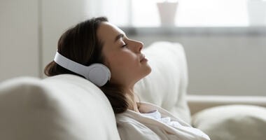 Dziewczyna słucha przez słuchawki relaskującej muzyki