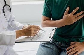 scyntygrafia serca, wskazanie do scyntygrafii serca, na czym polega scyntygrafia serca, mężczyzna u lekarza trzymający się za serce