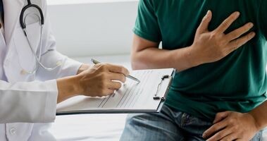 scyntygrafia serca, wskazanie do scyntygrafii serca, na czym polega scyntygrafia serca, mężczyzna u lekarza trzymający się za serce