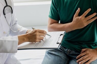 scyntygrafia serca, wskazanie do scyntygrafii serca, na czym polega scyntygrafia serca, mężczyzna u lekarza trzymający się za serce