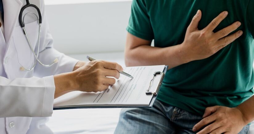 scyntygrafia serca, wskazanie do scyntygrafii serca, na czym polega scyntygrafia serca, mężczyzna u lekarza trzymający się za serce