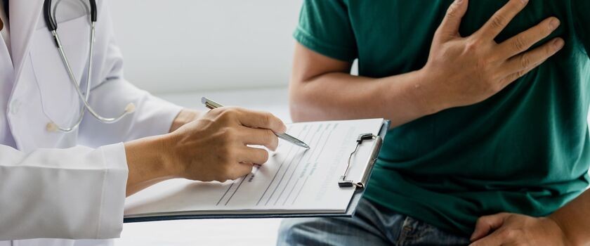 scyntygrafia serca, wskazanie do scyntygrafii serca, na czym polega scyntygrafia serca, mężczyzna u lekarza trzymający się za serce