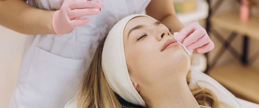 zabiegi kosmetyczne zimą, jakie zabiegi wykonywać zimą, kobieta podczas zabiegu u kosmetologa, pielęgnacja twarzy zimą