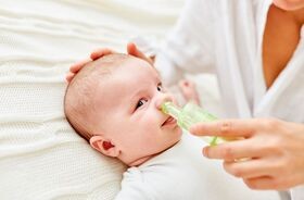 Czyszczenie nosa noworodka i niemowlaka. Niemowlę podczas odciągania kataru.