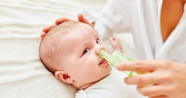 Czyszczenie nosa noworodka i niemowlaka. Niemowlę podczas odciągania kataru.