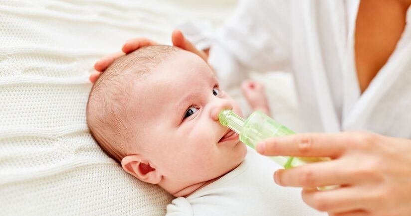 Czyszczenie nosa noworodka i niemowlaka. Niemowlę podczas odciągania kataru.