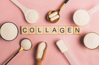 Napis collagen na drewnianych klockach otoczony różnymi formami kolagenu - w proszku, w tabletkach