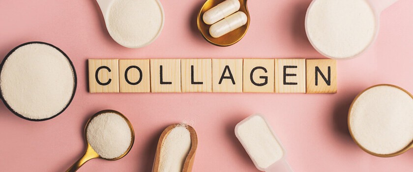 Napis collagen na drewnianych klockach otoczony różnymi formami kolagenu - w proszku, w tabletkach