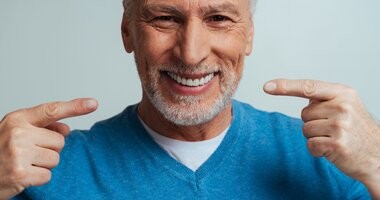 Starszy mężczyzna uśmiecha się, pokazując zęby
