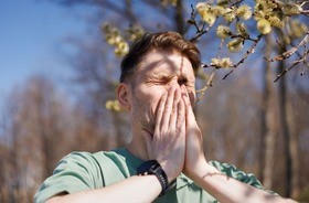 mężczyzna kichający z powodu alergii, alergia, objawy alergii, czym jest alergia, rodzaje alergii, leczenie alergii, alergeny