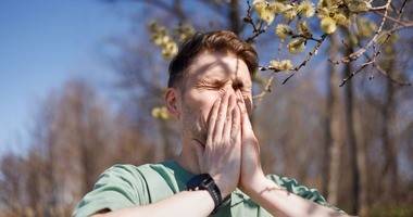 mężczyzna kichający z powodu alergii, alergia, objawy alergii, czym jest alergia, rodzaje alergii, leczenie alergii, alergeny