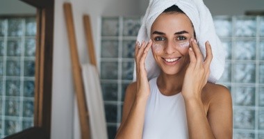 Młoda kobieta aplikuje krem na twarz