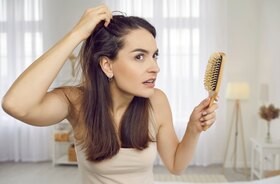 Kobieta przed lustrem sprawdza jakośc jej włosów