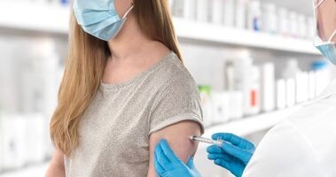 Kobieta przyjmująca szczepienie w aptece.