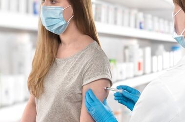 Kobieta przyjmująca szczepienie w aptece.