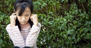 Dziewczynka cierpiąca na mizofonię zatyka uszy