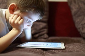 dziecko wpatrujące się w ekran tabletu