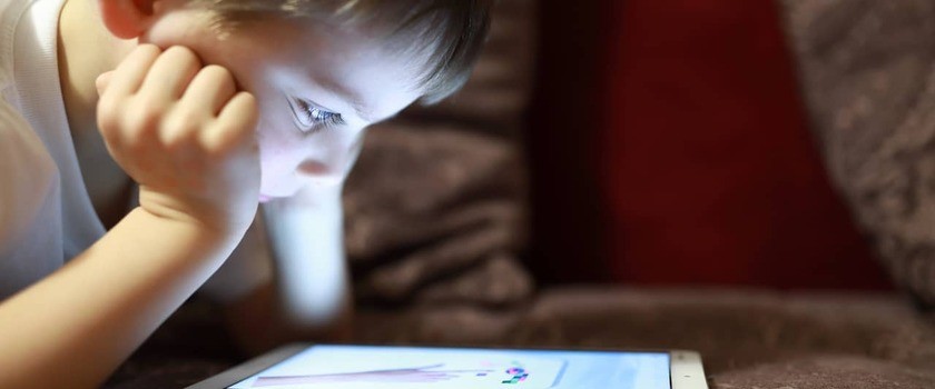 dziecko wpatrujące się w ekran tabletu