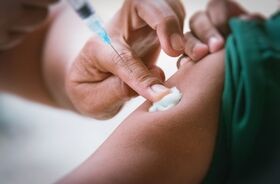 Podanie szczepionki na krztusiec. Ręka medyka dociskająca wacik na ramieniu zaszczepionego pacjenta. szczepienie krztusiec