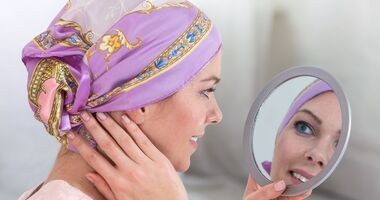 zabiegi kosmetyczne w trakcie choroby nowotworowej, leczenie onkologiczne a zabiegi medycyny estetycznej, kobieta z nowotworem patrzy w lustro
