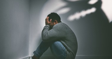 Człowiek cierpiący na zespół stresu pourazowego kuli się w kącie na wspomnienie swej traumy