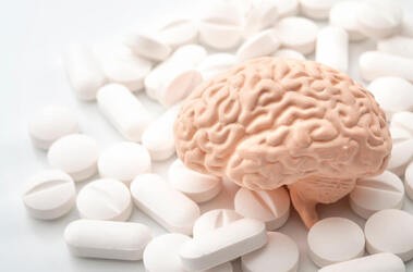 Tabletki smart drugs rozsypane wokół modelu mózgu