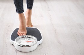 Szczupła kobieta z otyłością ukrytą (syndrom TOFI) na wadze