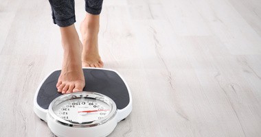 Szczupła kobieta z otyłością ukrytą (syndrom TOFI) na wadze