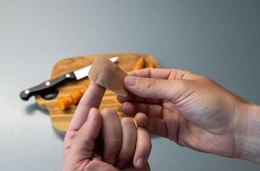 Dłonie opatrujące ranę od noża. Skaleczenie, drobne urazy skóry, siniaki, jak opatrzyć skaleczenie.