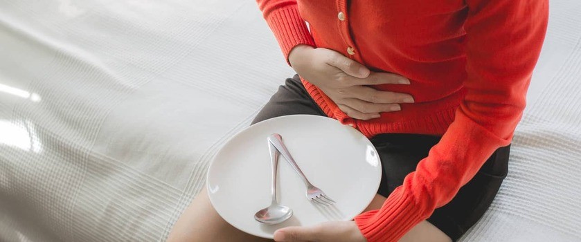 Kobieta z bólem brzucha po jedzeniu