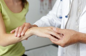 Kobiece dłonie pokazujące zespół cieśni nadgarstka